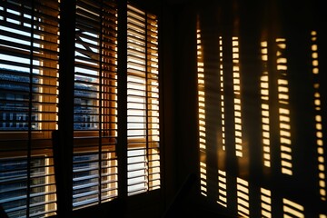 Wood blinds with striped reflection on the wall