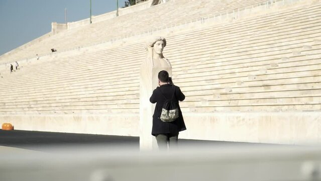 Slowmotion shot of a photographer taking photos of the stone head within the Panathenaic Stadium