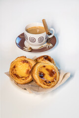 Pasteis de nata, traditional sweet of Portuguese cuisine. Small crunchy puff pastry pies and a cream made with eggs. Often tasted and accompanied with coffee. Isolated on white background, copy space.