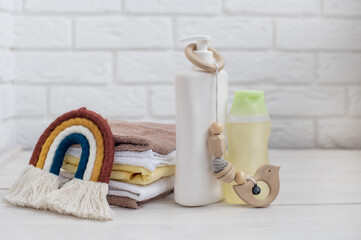 Baby accessories on table near white brick wall. Space for text.
