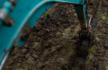 Close up of excavator or digger digging some a soil or clay, industrial concept