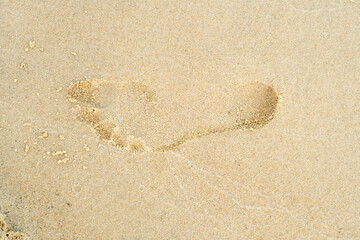 Footprint in the sand. Background on the theme of summer vacation and serene rest.