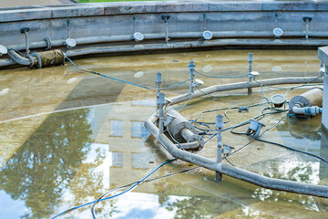 Shutdown city fountain without water, stopped for repairs for the winter. - obrazy, fototapety, plakaty