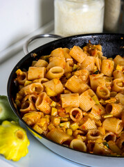 pasta with vegetables in a large frying pan, italian cuisine