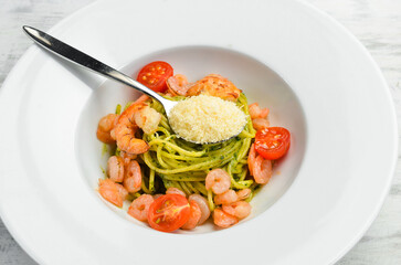 Pasta with shrimp, cheese and pesto sauce. Italian cuisine. Menu. Top view.