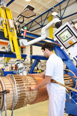 young mechanical engineering workers operate a machine for winding copper wire - manufacture of...