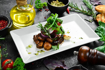Grilled vegetables on a plate, restaurant serving of food. Eggplant, mushrooms, zucchini and tomatoes. Top view. Free space for text.