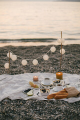 Romantic picnic by the sea at sunset.