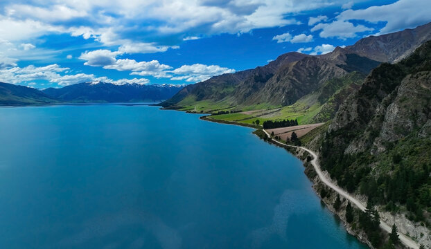 Aerial view of road between green forest and blue hawea lake New zealand © SASITHORN