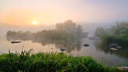 Fantastic foggy river with fresh green grass in the sunlight. Sun beams through tree island. Dramatic colorful scenery. South buh riverl. Ukraine, Europe. Beauty world nature background - 549967566