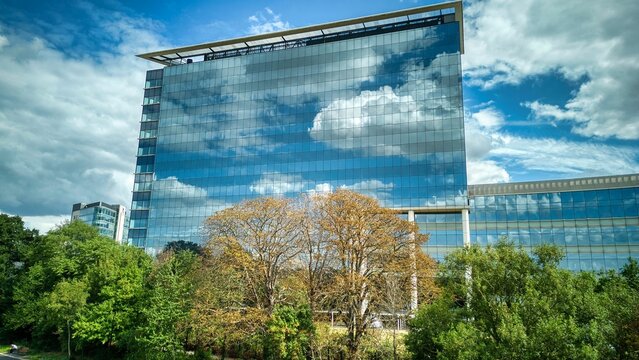 GSK (GlaxoSmithKline) building with clouds reflected on its grass windows in Brentford, London