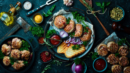 A set of fried meat, cutlets and shish kebab, handmade recipe. On a black stone background. Top view.
