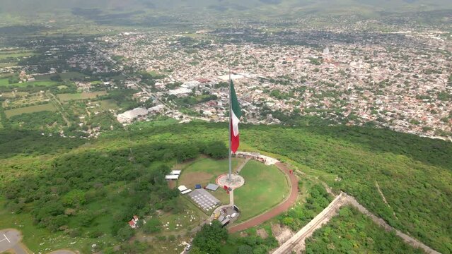 Flying around Mexican Independence flag over the mountains of Iguala in Guerrero, Mexico