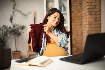 Fototapeta premium Young woman having video call. Beautiful pregnant woman in office..