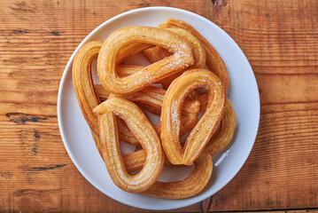 Churros caseros sobre una superficie de madera en una vista cenital