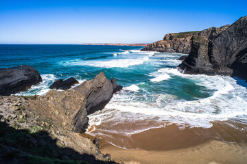 ocean view in Portugal. coast, steep cliffs, empty beaches, wild nature. The rock walls of the coast. waves on the ocean. West coast of Portugal. Daylight, horizontal
