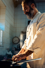 Chef cooking in a commercial kitchen choping vegetable.