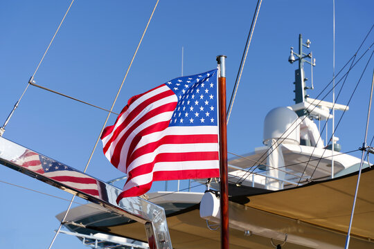 USA flag. Waving flag of the United States of America on a flagpole on a ship at sea.