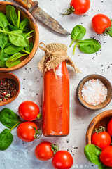 Homemade Tomato Juice in a Glass Bottle. Top view. On a stone background.