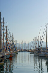 Fototapeta na wymiar Pier with yachts. Many beautiful yachts with masts in the marina. Vacation, travel, luxury concept