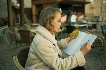 Girl draws an autumn leaf from nature