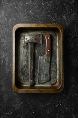 Old kitchen utensils on a metal kitchen tray on a black stone background. Retro tableware. Free space for text.