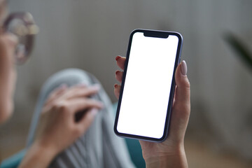 Mock up white screen blank close up mobile phone in woman hands holding Back view