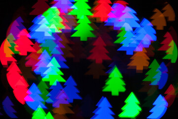Christmas tree shape bokeh of colorful electric garland. The picture was taken with a shaped lens attachment