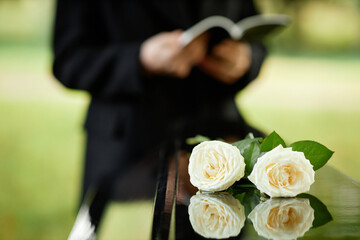 Closeup of two white roses on coffin at outdoor funeral ceremony, copy space - obrazy, fototapety, plakaty