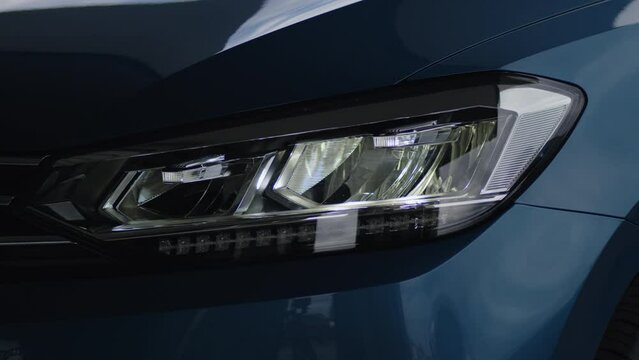 Close-up of a modern car's headlight turning on and adjusting angle.