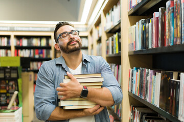 Cheerful reader feeling happy buying a lot of books