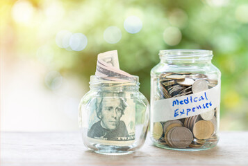Coins adn dollar billsin glass jar with medical expenses label.
