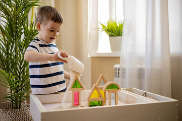 Cute baby boy playing sand table therapy toys developing game at home. Early development