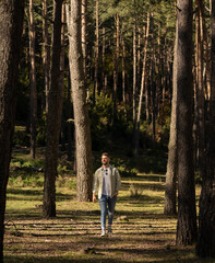Chico joven modelo paseando en el bosque