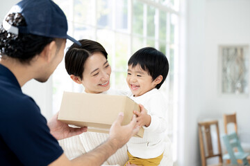 玄関で配送を受け渡しするイメージ 笑顔で受け取る子ども