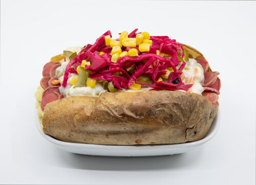 Kumpir, Turkish baked potato with cheese, corn, sausage, ketchup, mayonnaise and olives. This kumpir is traditional Turkish food isolated on white background