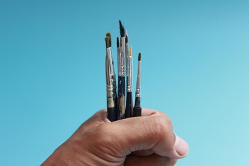 a close up of a hand holding a painting brush