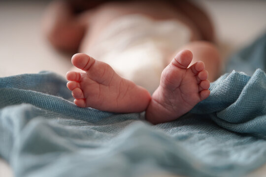 Newborn Baby's foot with a blue blanket. Close up a baby's foot.