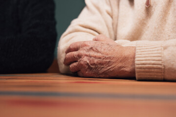 Close up of elderly male hands on wooden table