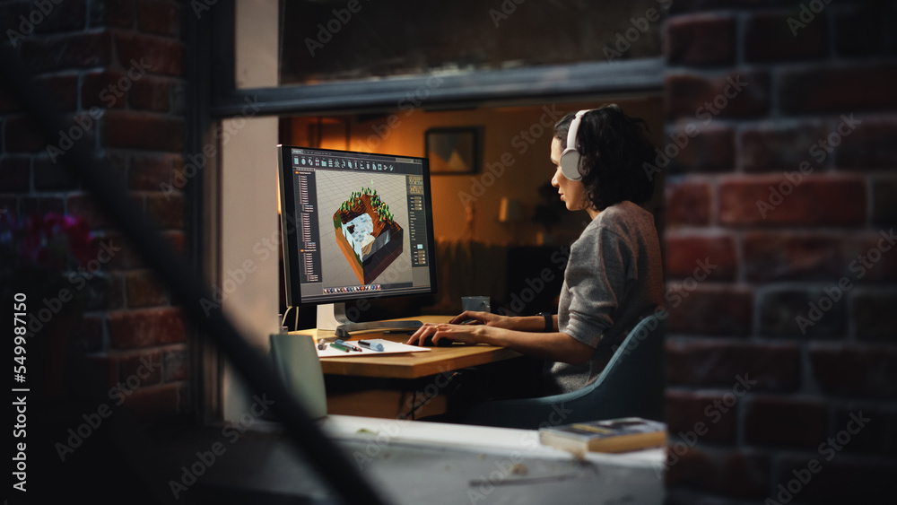 Aufkleber Female Video Game Designer Works on a New 3D Level on Her Personal Computer. Focused Woman Creating Metaverse and Design Video Game. Shot Into the Apartment Window Late at Night.
