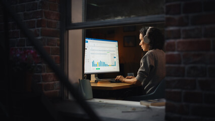 Hispanic Woman Developer Working in Evening on a Desktop Computer in Home Environment. Beautiful Diverse Latin Female Software Engineer is Checking Her Tasks at the Dashboard.