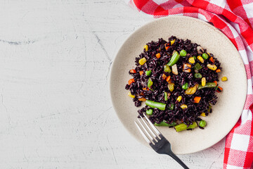 delicious black rice with vegetables on a white background