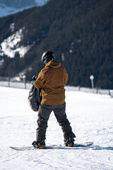 Fototapeta na wymiar Male snowboarder on top of mountain in Austria with equipment. High quality image of snowboarding man on snowy mountain.