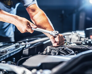 Auto mechanic working in garage. Repair service.