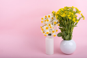 ピンクバックの花瓶に挿した菜の花と水仙の花