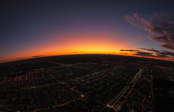 Panoramic Aerial View Of City Landscape At Dusk With Dramatic Sky.