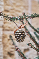 Christmas tree is decorated with natural pine tree cone painted in gold. Handmade Christmas decorations zero-waste and no plastic concept