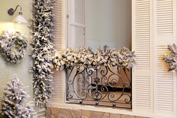 Snow covered balcony with wrought french iron railings with open shutters and doors. Old window...