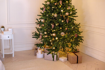 Fototapeta premium Festive interior design living room with a Christmas tree and decorations. Xmas at home. New year winter home decor. Christmas tree with lights glowing garlands and gifts. 
