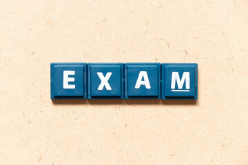 Tile letter in english word exam on wood background